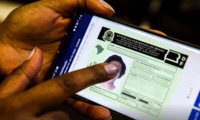 Trânsito com diversos carros em via urbana durante debate sobre renovação automática da CNH. 🚗📄