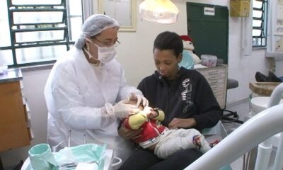 Dentista realiza exame ortodôntico em criança durante consulta