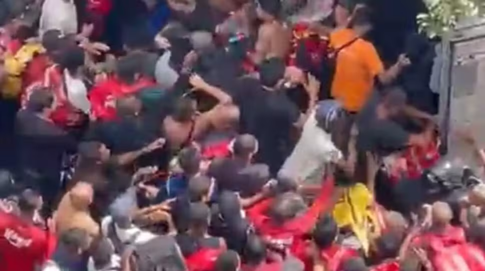 Entregadores reunidos ao redor de caminhão durante distribuição de bolsas na Barra da Tijuca